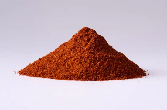 Finely ground paprika powder mound showcasing vibrant color and texture against a minimalist backdrop.