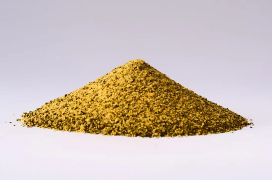 Finely ground yellow spice powder in a conical mound, perfect for culinary uses.